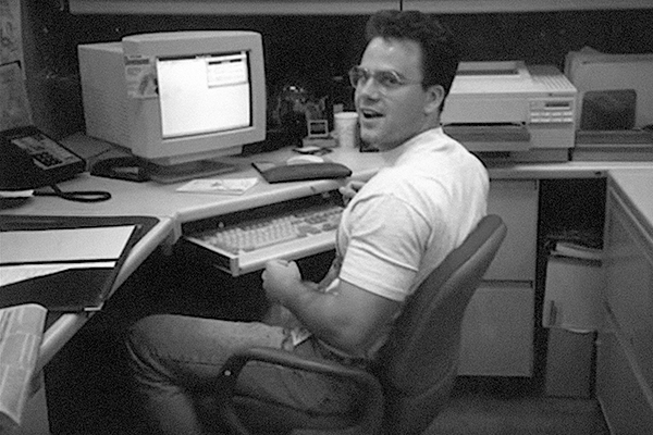 John Harms sitting at his desk at work